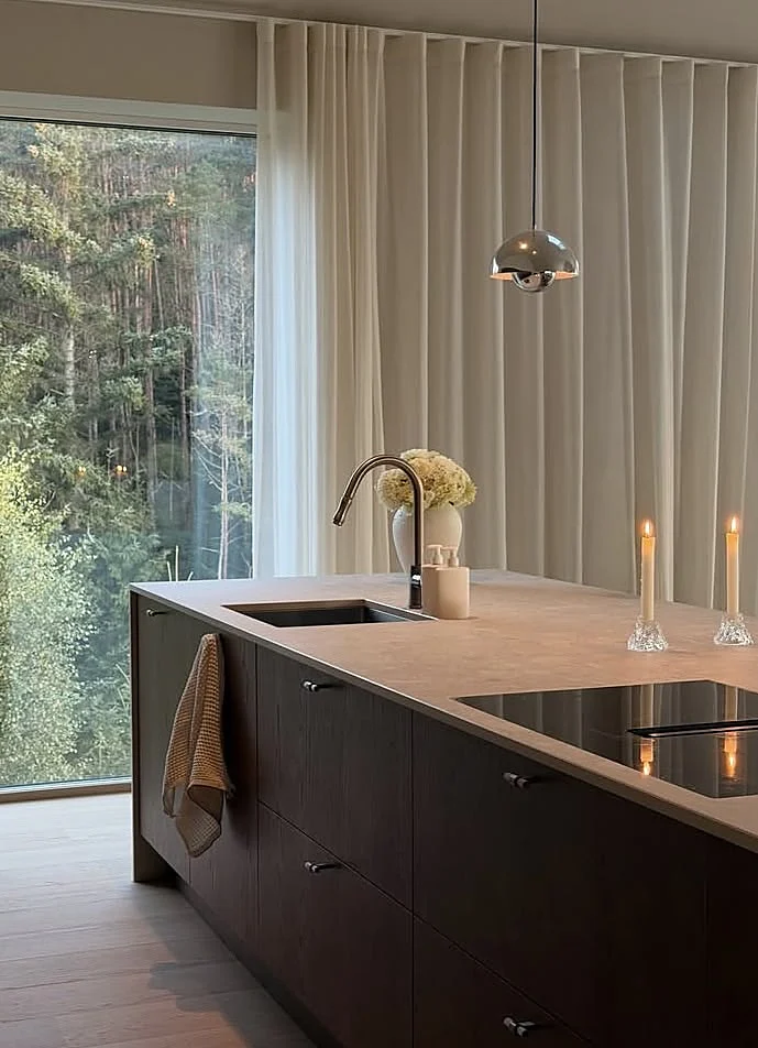 Dark wood kitchen island with a natural stone worktop Dark wood kitchen island with a natural stone worktop, undermount sink and flush induction hob
