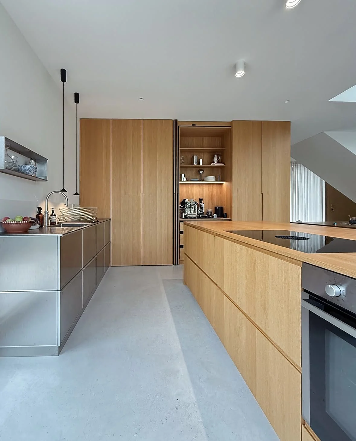 Oak veneer kitchen with stainless steel base units and a pocket-door coffee pantry